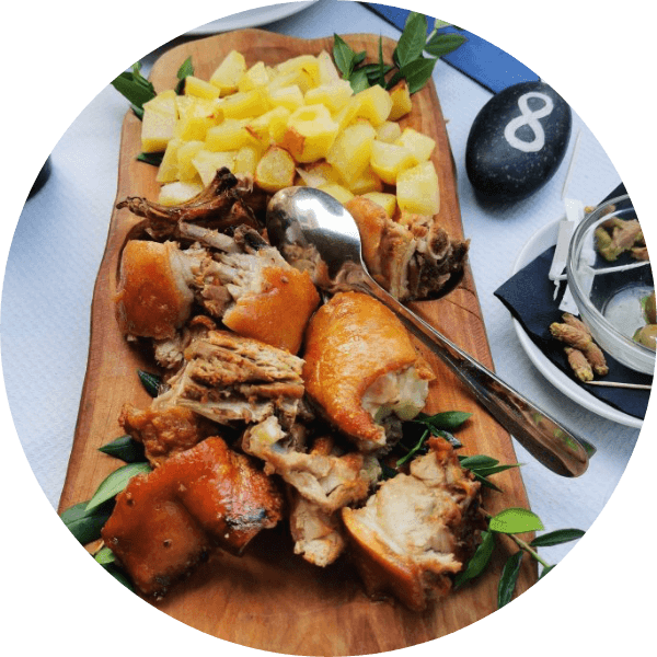 Tagliere con porchetta croccante e patate dorate, atmosfera rustica e conviviale.